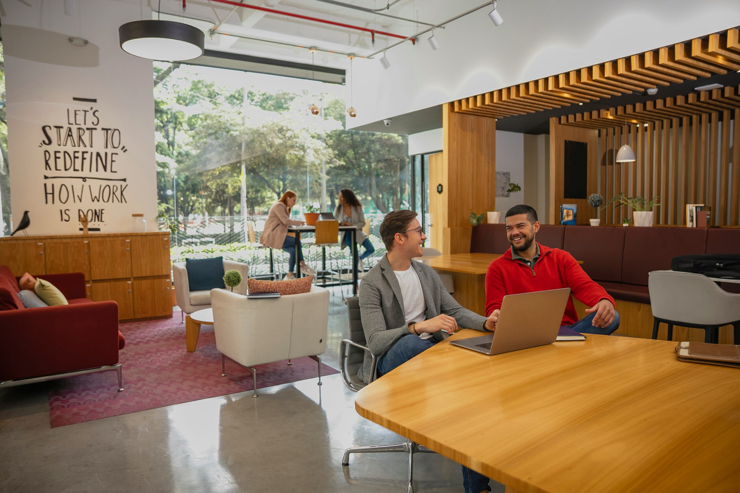 Uma equipe trabalhando em uma empresa com uma impressora laser no fundo.