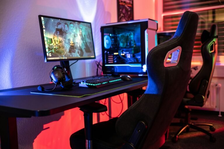 Setup de computador com cadeira gamer organizado dentro do quarto de uma casa.