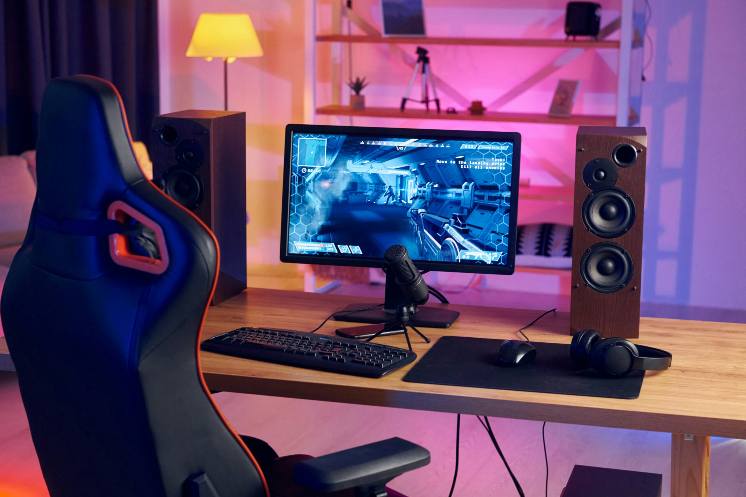 Setup de computador com cadeira gamer organizado dentro do quarto de um apartamento.