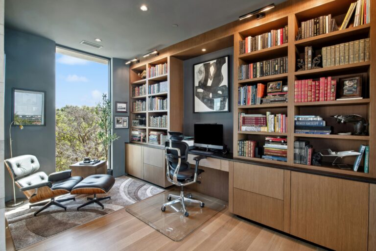 Um ambiente de home office equipado com uma biblioteca, mesa, computador e vários itens de escritório.