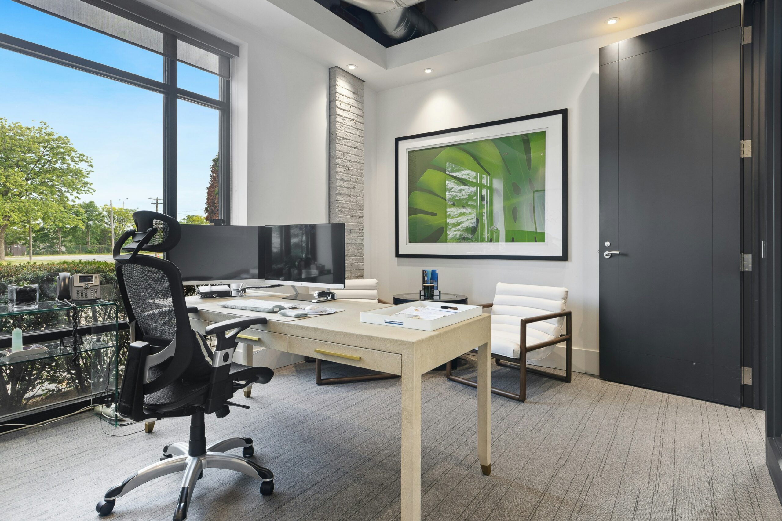 Um home office montado em uma casa de dois andares, com destaque para a vista para o jardim.