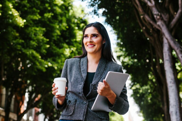 Mulher a caminho do trabalho segurando um tablet de forma prática durante o seu deslocamento diário.