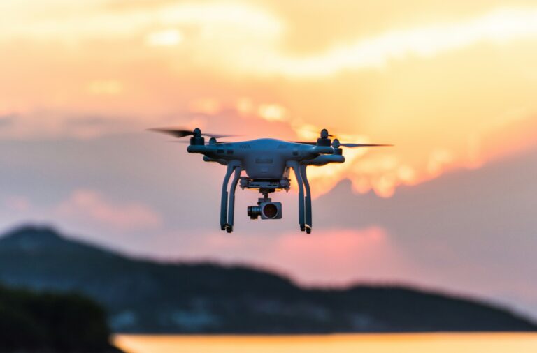 Drone voando sobre a praia gravando imagens aéreas do mar e da costa.