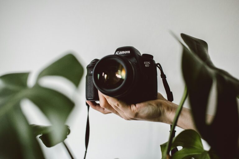 Mãos de uma pessoa segurando uma câmera fotográfica pronta para tirar uma foto.